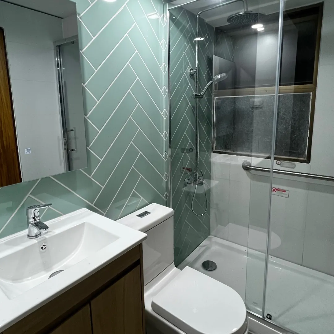 El mismo baño de Carlos Antúnez terminado, con cerámica nueva y ducha de vidrio